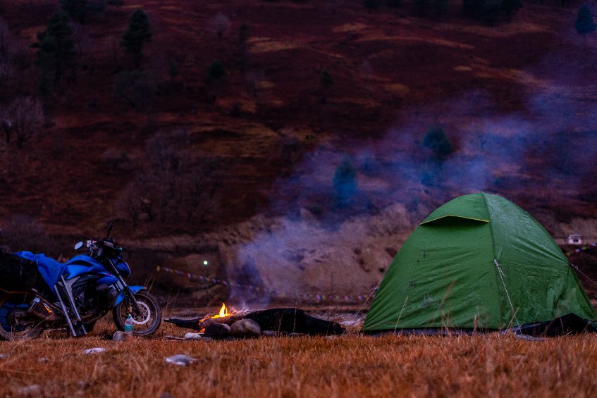 Motard campant pour la nuit dans une tente verte