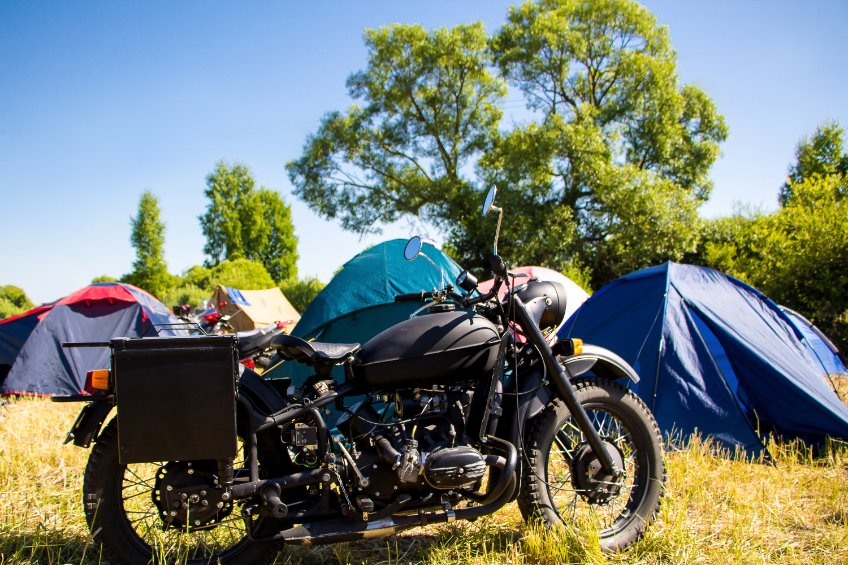 Tentes de camping avec une moto garée au premier plan